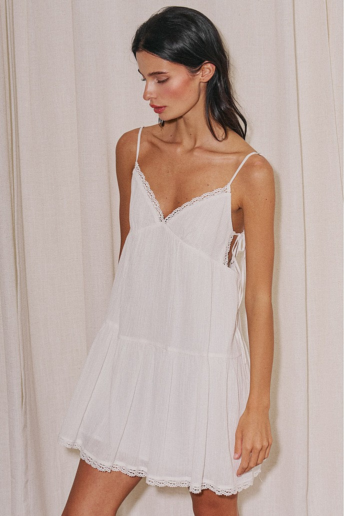 White babydoll mini dress with lace neckline side ties and relaxed cotton fit