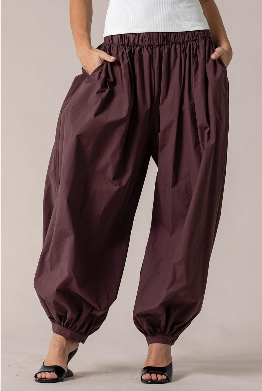 Model wearing merlot cotton harem pants with elastic waist, pockets and banded hem