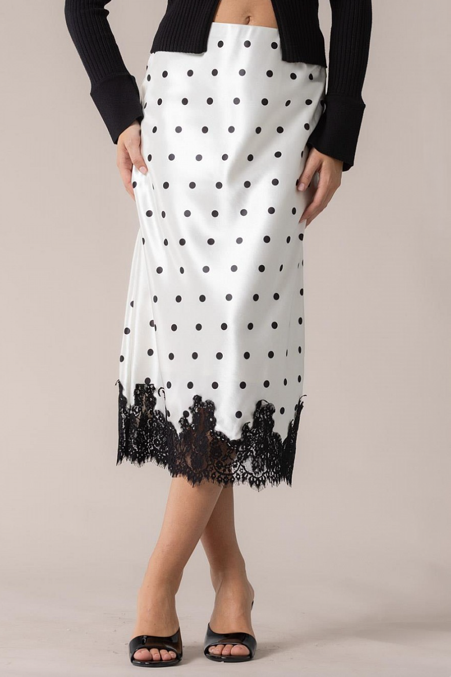 White satin polka dot midi slip skirt with black lace hem, front view on model