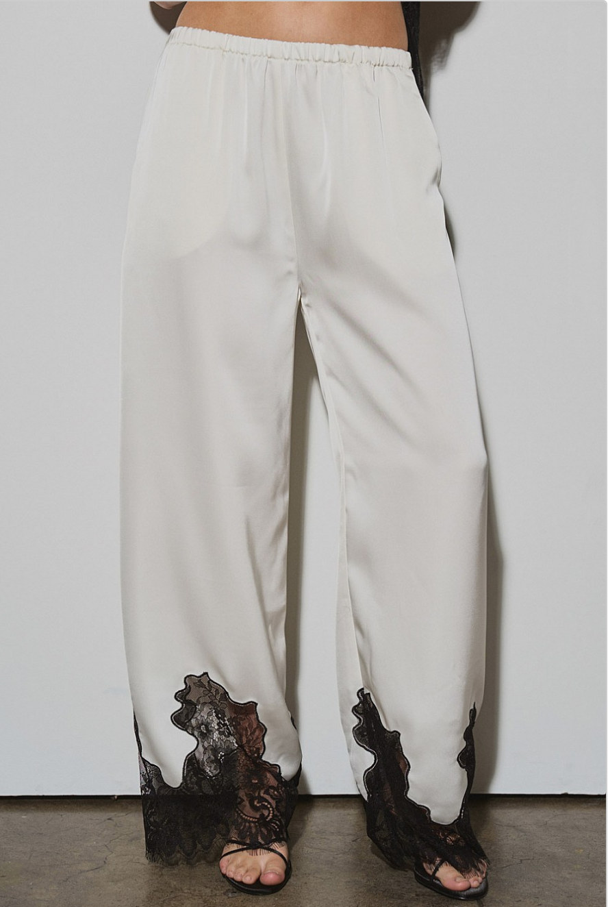 Front view of ivory satin pants with black nylon lace contrast at hem