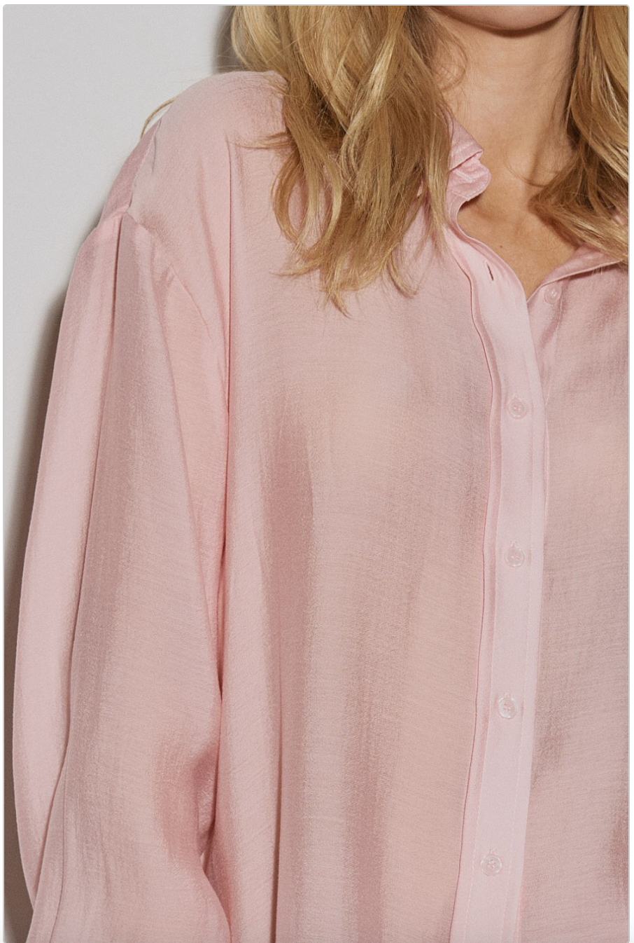 Close-up of blush pink sheer woven button-down shirt showing lightweight fabric texture and front button placket.