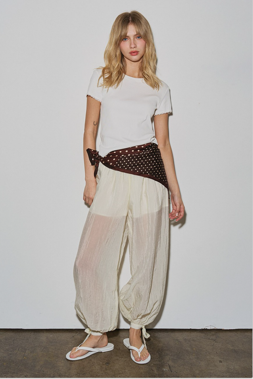 Model wearing Willow Balloon Pant with white tee, front view, sheer textured legs and tie hems.