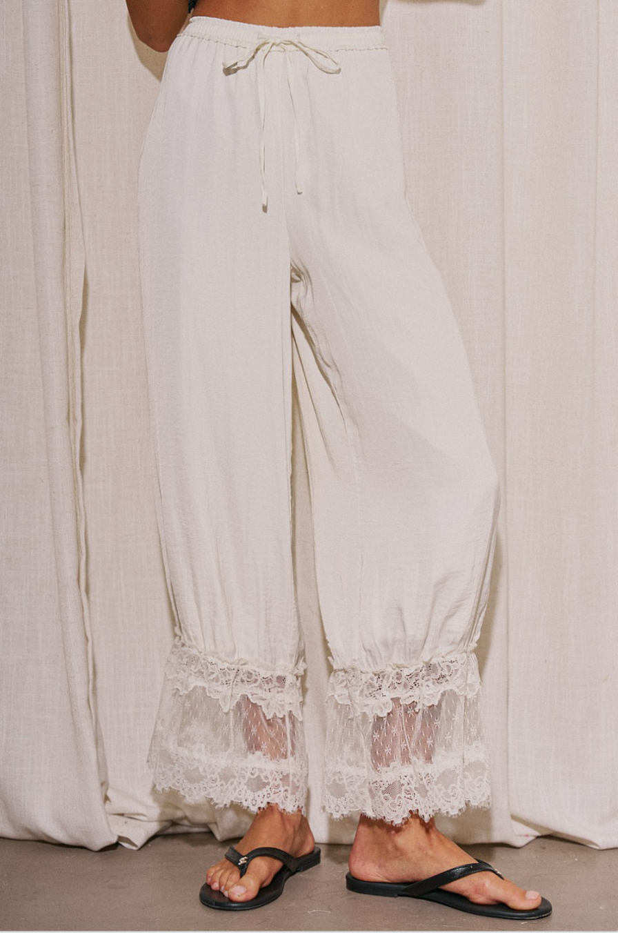 Front view of Living in the Clouds ivory lace hem pants with drawstring waist