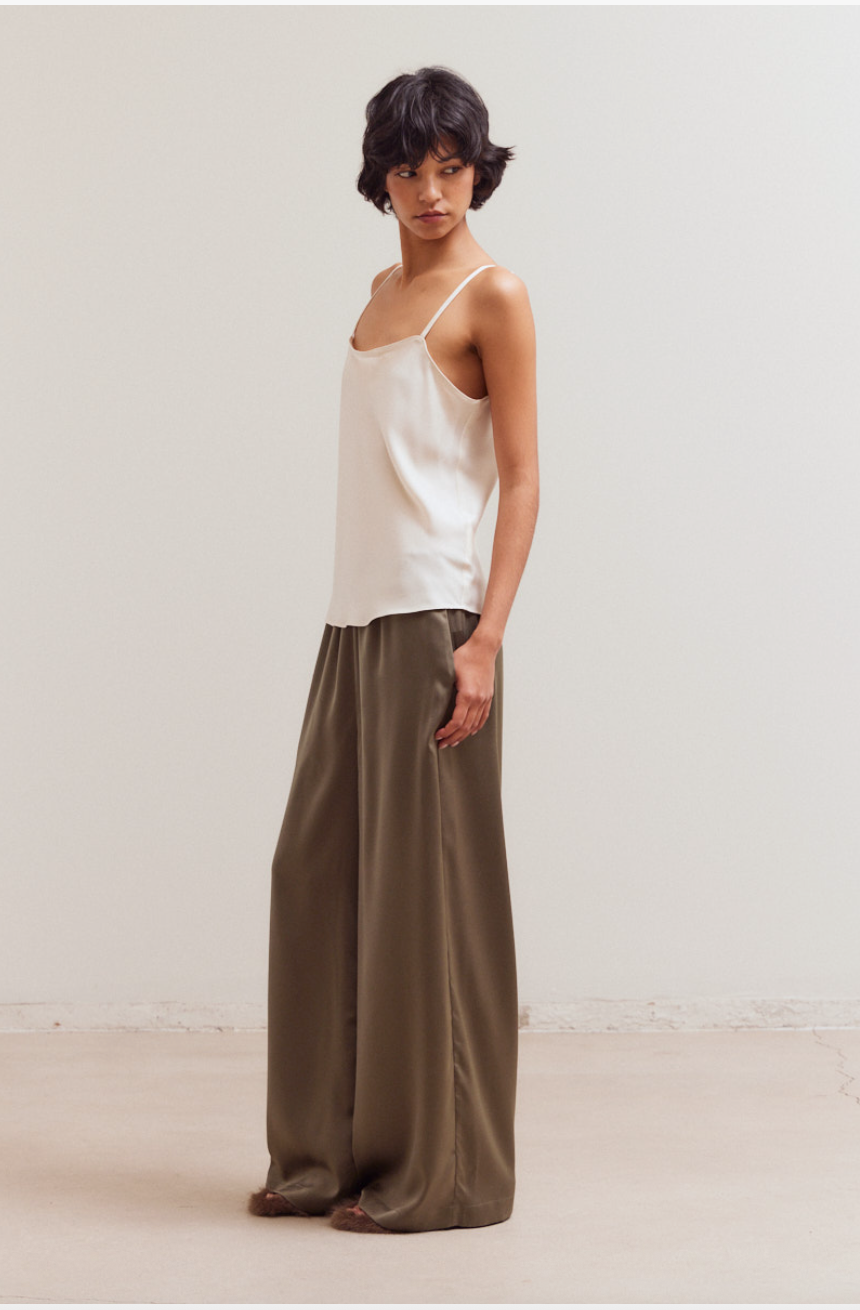 Side view of olive satin wide leg pants with relaxed pull-on fit and side pocket detail