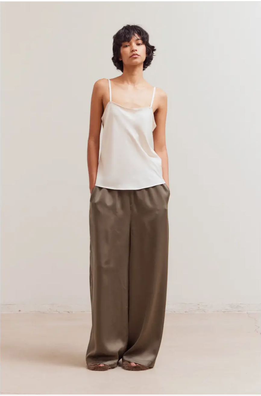 Front view of The Sienna Satin Palazzo Pant showing smocked waist, side pockets, and fluid wide-leg satin drape